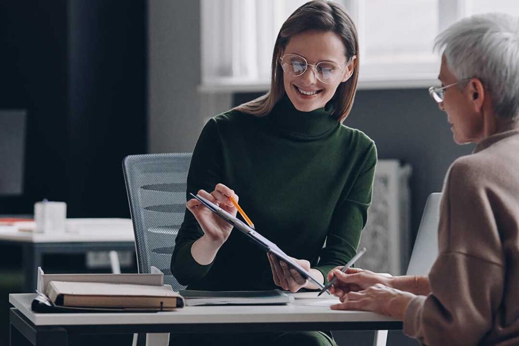 Older couple reviewing care planning papers with an adult family member at a kitchen table.